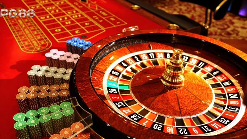 PG88 roulette: bánh xe quay, bảng cược và chip trên bàn casino.